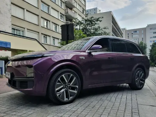 Une élégante li auto violette se gare devant des immeubles résidentiels.