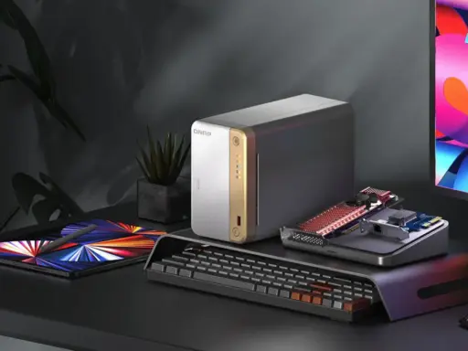 Un bureau moderne avec un NAS QNAP, une tablette, un clavier et un écran coloré. Idéal pour choisir son NAS et organiser ses données.