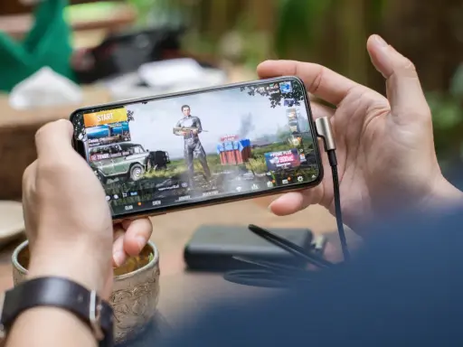 Main d'une personne tenant un smartphone affichant un jeu vidéo, parfait pour les jeux sans connexion.