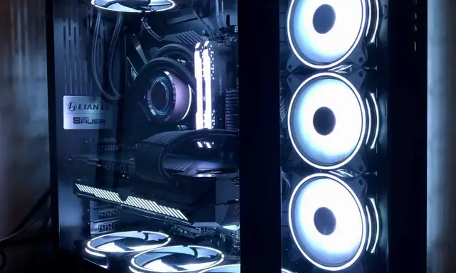 Intérieur d'un PC gamer avec éclairage RGB. On distingue la carte graphique, la carte mère, le système de refroidissement liquide et plusieurs ventilateurs. L'alimentation PC est bien visible.