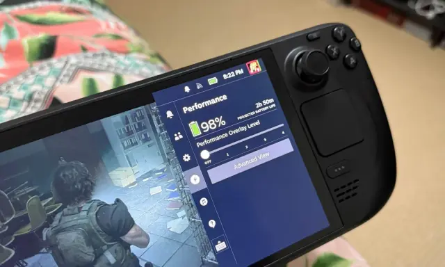 Une partie d'un Steam Deck 2 affiche un jeu et le menu performance avec 98% de batterie.