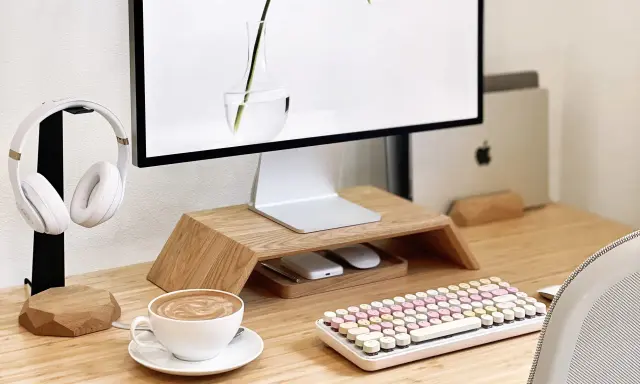 Un café latte, un clavier pastel et un casque blanc composent ce setup bureau idéal pour travailler avec style.