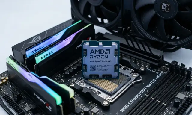Un processeur AMD Ryzen 7 9850X3D est posé sur une carte mère ROG Crosshair X670E Hero, entouré de barrettes de RAM G.Skill Trident Z5 RGB et d'un ventirad Noctua.