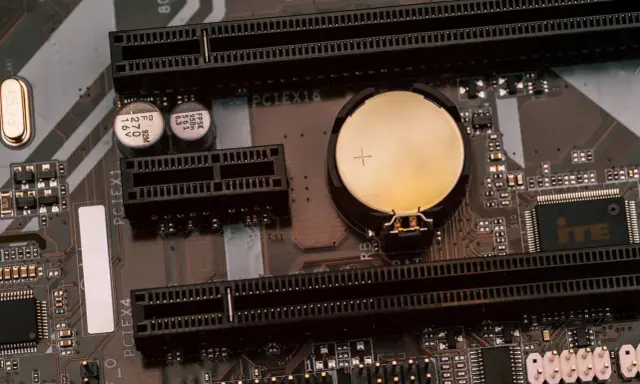 Carte mère MSI avec une pile bouton pour le clear CMOS, des slots PCI Express et des condensateurs.