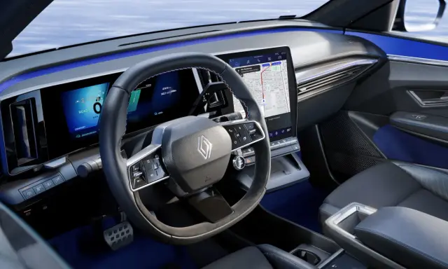 Tableau de bord moderne de la future Renault Mégane, avec écrans numériques, volant multifonction et éclairage d'ambiance bleu.