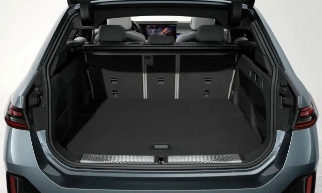 Vue du coffre ouvert d'une Tesla Model Y, montrant son espace de chargement spacieux et les sièges arrière.