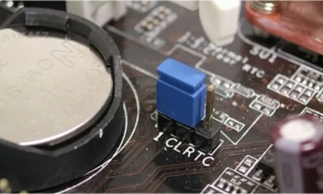 Gros plan sur une carte mère, montrant la pile bouton et le cavalier CLRTC pour réinitialiser le CMOS.