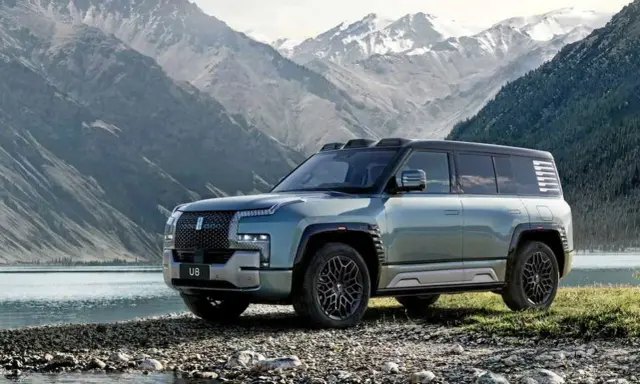 Le byd yangwang u8, un SUV imposant, se tient au bord d'un lac, avec des montagnes enneigées en arrière-plan.