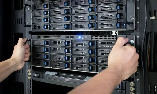 Mains d'un technicien installant des disques dans un nas server.