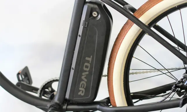 Batterie noire "TOWER" sur un vélo électrique, prête pour son homologation. Pédalier et roue arrière visibles.