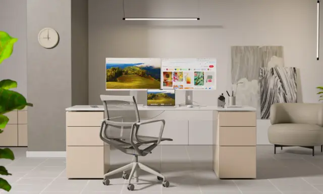 Bureau moderne avec un **écran ergonomique** double, une chaise confortable et une plante verte.