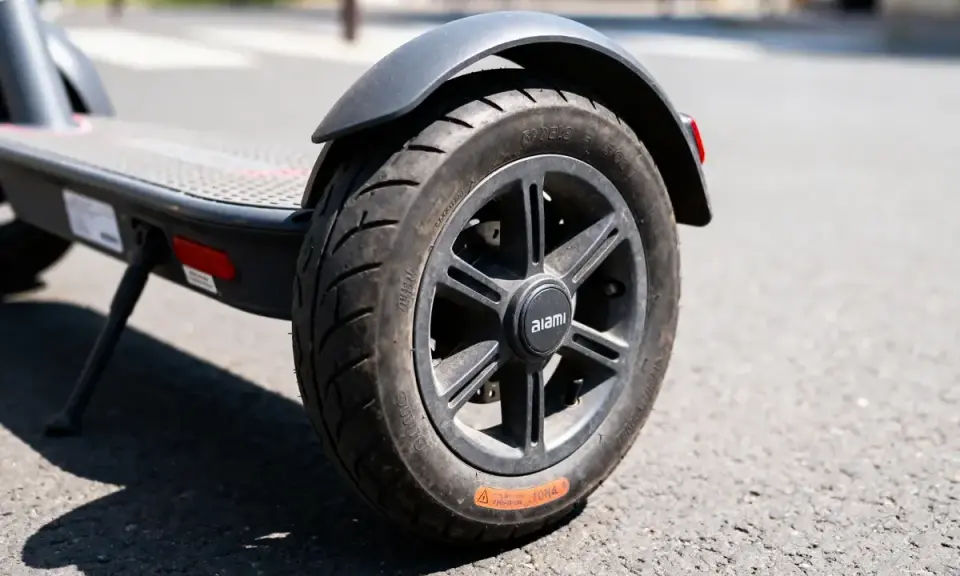 Roue de trottinette électrique sur la route. Le pneu semble dégonflé, rendant impossible de gonfler pneu trottinette.