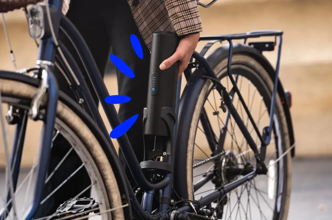 Une main retire la batterie d'un vélo électrique. Faut-il enlever la batterie sur un vélo électrique pour le recharger ou le stocker ?