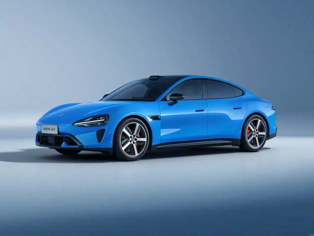 La Xiaomi SU7, une berline électrique bleue éclatante, se présente avec un design futuriste et des lignes aérodynamiques.
